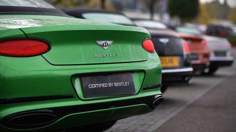 A photo of the rear end of a green Bentley sports car. 