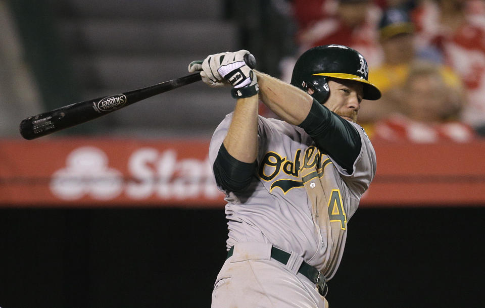 Oakland Athletics' Brandon Moss hits a RBI single during the eighth inning of a baseball game against the Los Angeles Angels on Tuesday, April 15, 2014, in Anaheim, Calif. (AP Photo/Jae C. Hong)