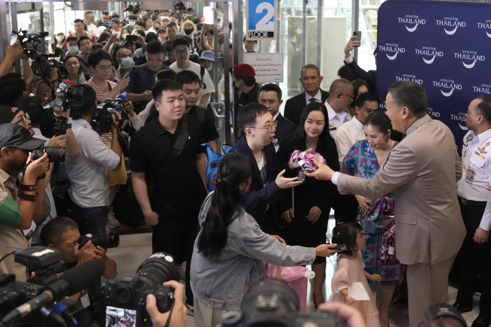Chinese tourists receive garlands from Thailand's Prime Minister Srettha Thavisin, right, on their arrivals at Suvarnabhumi International Airport in Samut Prakarn province, Thailand, Monday, Sept. 25, 2023. Thailand's new government granting temporary visa-free entry to Chinese tourists, signaling that the recovery of the country's tourism industry is a top economic priority. (AP Photo/Sakchai Lalit)