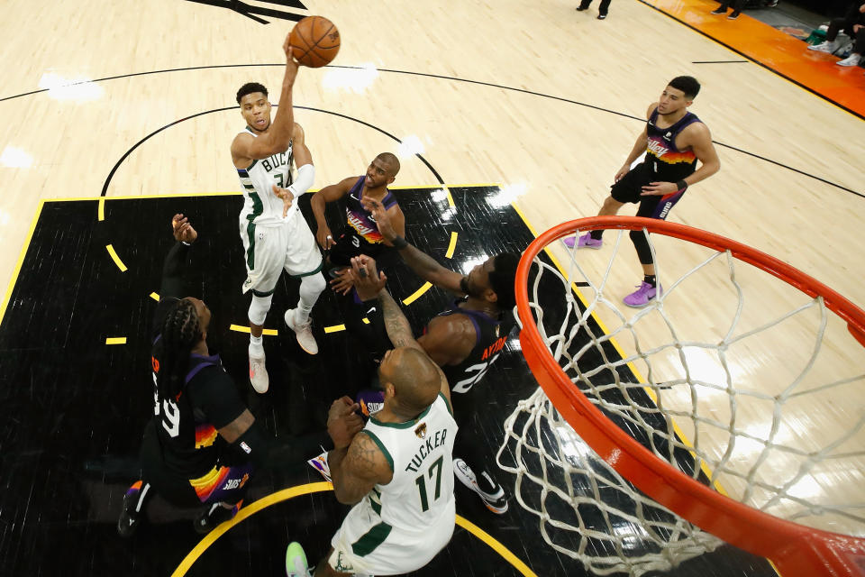 Giannis Antetokounmpo makes a leaping pass over Chris Paul during Game 1 of the NBA Finals.