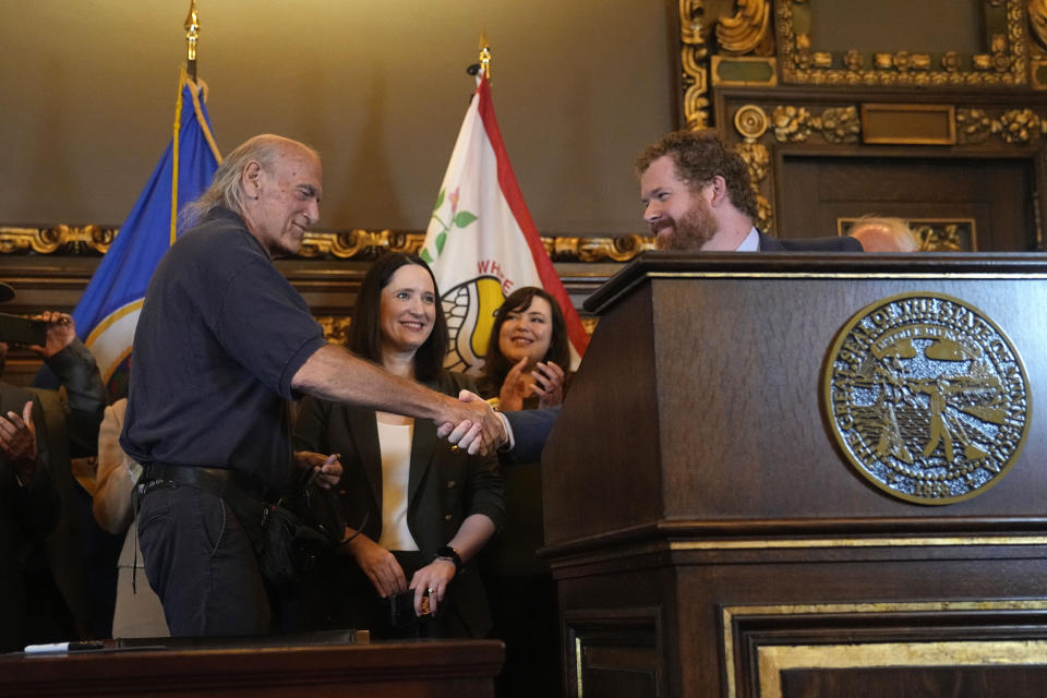 Former Minnesota Gov. Jesse Ventura, left, shakes hands with Minnesota State Representative Zack Stephenson before the bill signing by Minnesota Gov. Tim Walz to legalize recreational marijuana for people over the age of 21, making Minnesota the 23rd state to do so, Tuesday, May 30, 2023, in St. Paul, Minn. (AP Photo/Abbie Parr)