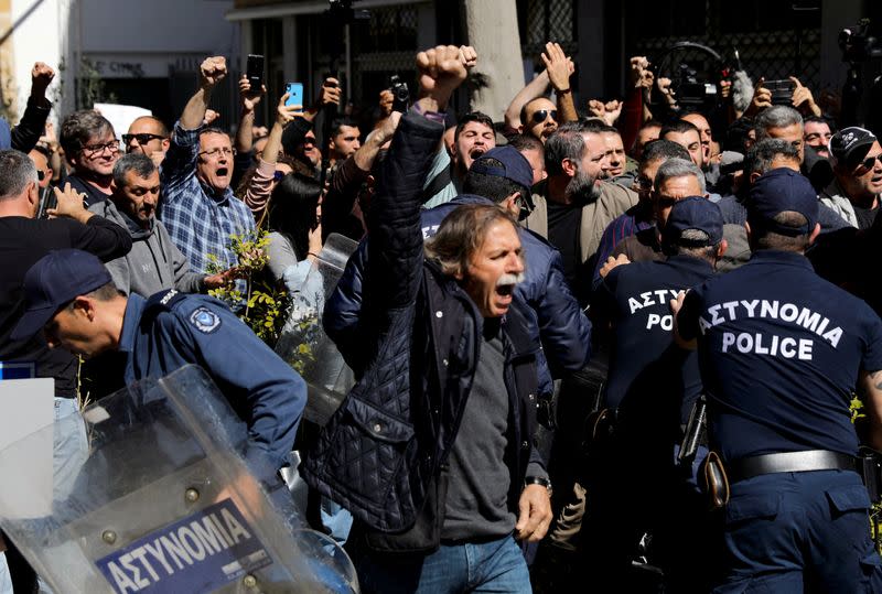 Turkish Cypriots shout slogans at the Ledra checkpoint of the U.N.-controlled buffer zone, after authorities declared the crossing temporarily shut to curb any potential spread of coronavirus, in Nicosia