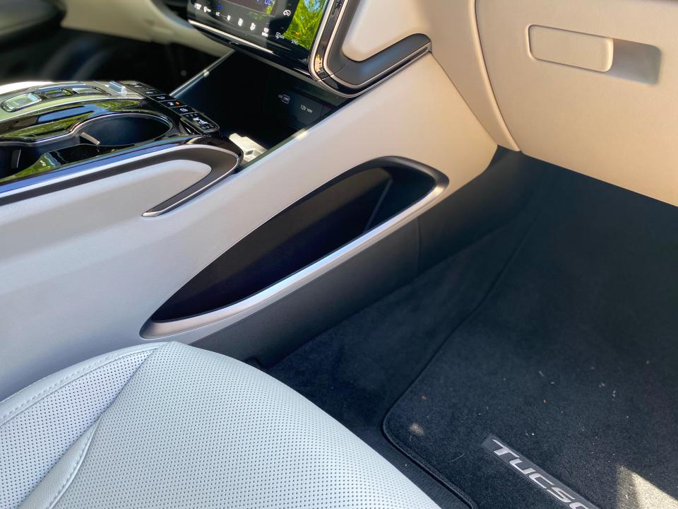 The passenger seat footwell and map pockets of a 2024 Hyundai Tucson Hybrid SUV.
