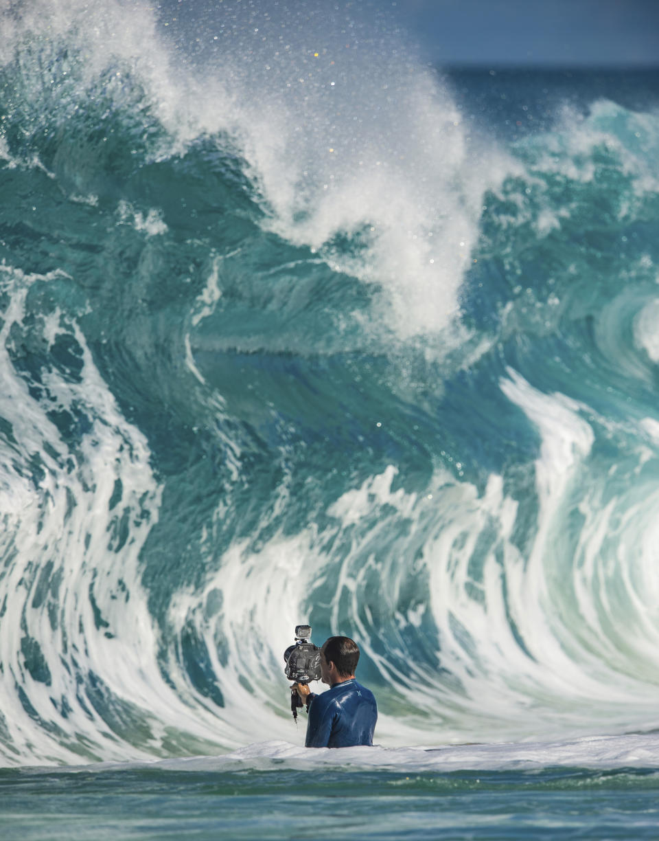 CORRECTS SPELLING OF PHOTOGRAPHER'S FIRST NAME TO JERRETT - In this undated photo provided by Jerrett Lau, Clark Little photographs waves on the North Shore of Oahu near Haleiwa, Hawaii. (Jerrett Lau via AP)