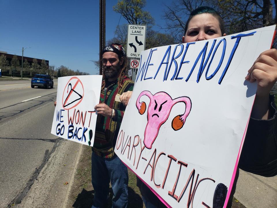 Danielle Wright, 25, and James Smith, 42, both of Croswell, hold signs at an abortion rights demonstration in Pine Grove Park Saturday, May 7, 2022.