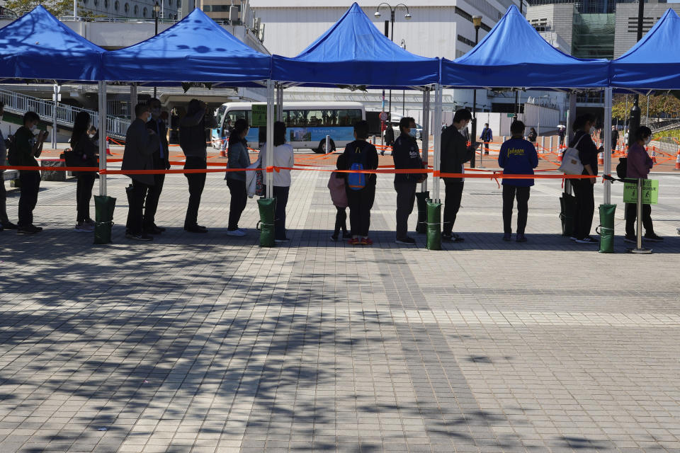 Residents queue up to get tested for the coronavirus at a temporary testing center for COVID-19 in Hong Kong, Monday, Feb. 14, 2022. (AP Photo/Vincent Yu)