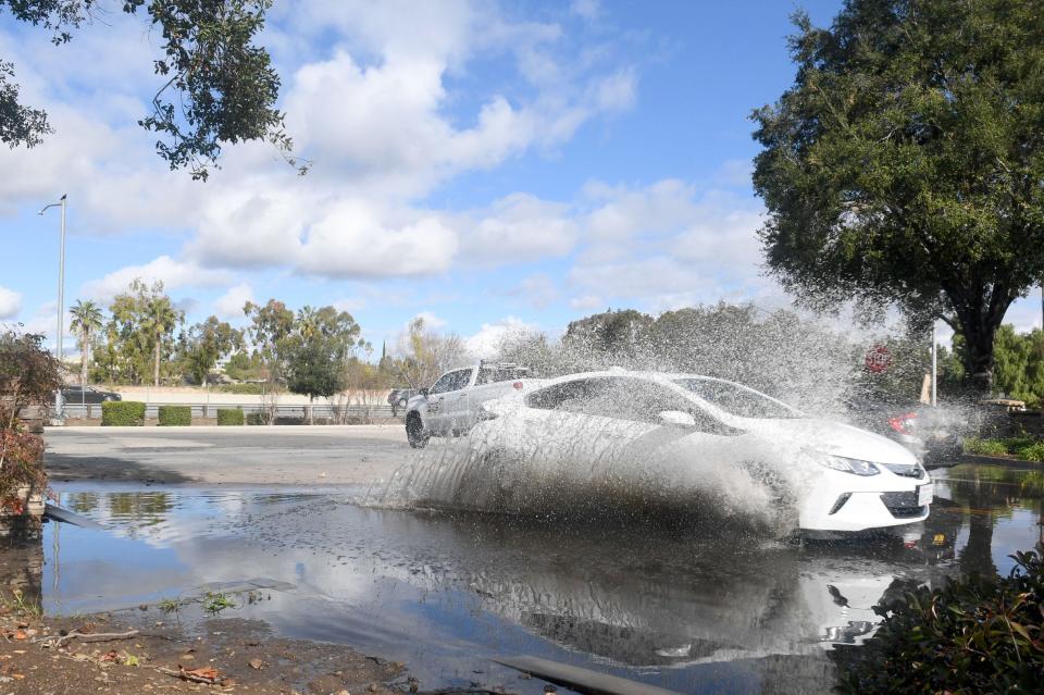 Cars drive through a huge puddle near the Kohl's parking lot in Newbury Park on Monday, Dec. 12, 2022. A series of storms drenched the region in recent days.