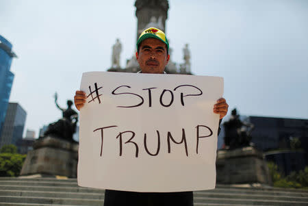 A demonstrator holds a placard during a protest against the visit of U.S. Republican presidential candidate Donald Trump, at the Angel of Independence monument in Mexico City, Mexico, August 31, 2016. REUTERS/Tomas Bravo