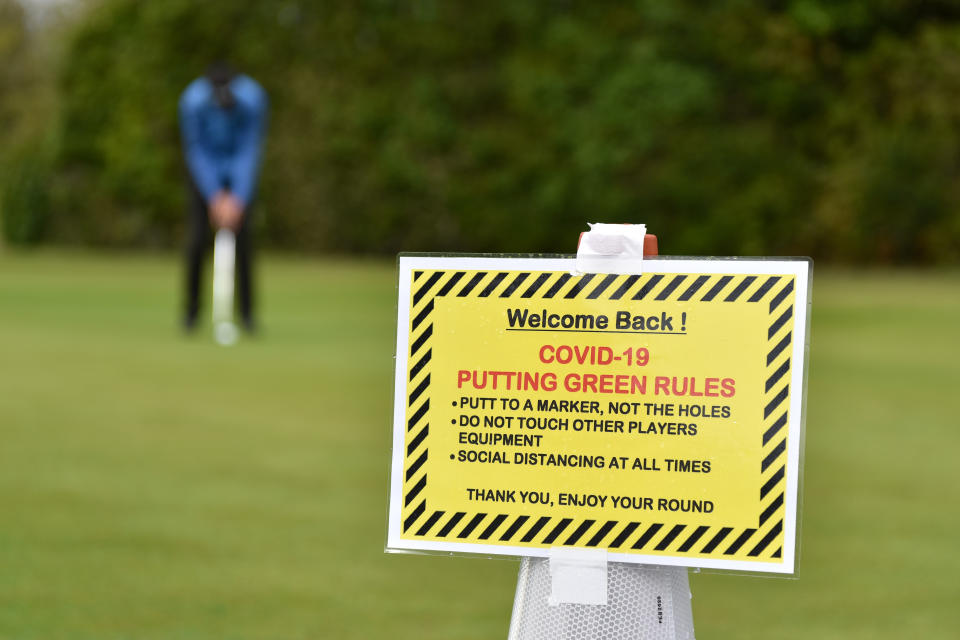 SOUTHEND ON SEA, ENGLAND -  MAY 13:  A "Welcome back" and Covid-19 safety sign as a golfer plays on the practice putting green as golf courses reopen in England under government guidelines during the Coronavirus (COVID-19) pandemic at Thorpe Hall golf course on May 13, 2020 in Southend on Sea, England. The prime minister announced the general contours of a phased exit from the current lockdown, adopted nearly two months ago in an effort curb the spread of Covid-19. (Photo by John Keeble/Getty Images)