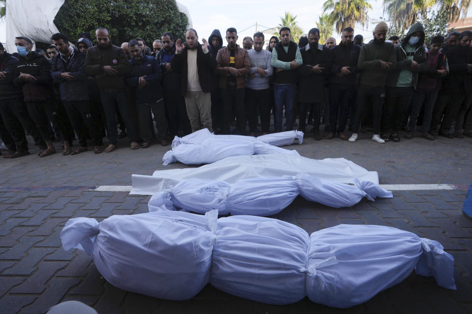 Palestinians mourn their relatives killed in the Israeli bombardment of the Gaza Strip in Deir al Balah on Wednesday, Dec. 20, 2023. (AP Photo/Adel Hana)