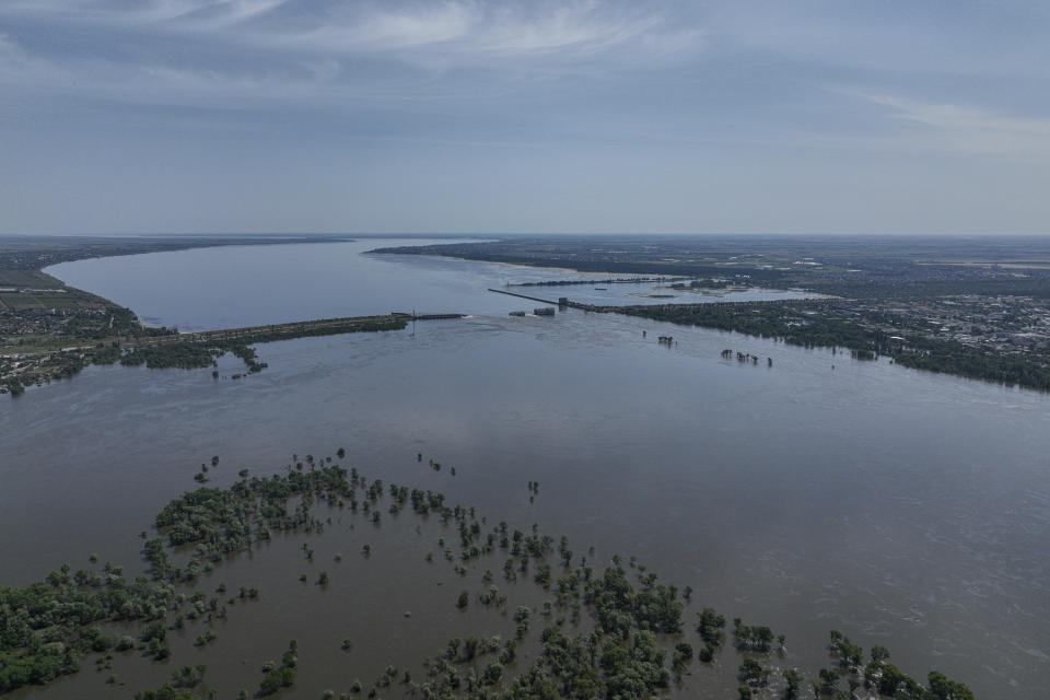 Un torrente de agua fluye por encima de la derrumbada represa de Kajovka, en Nova Kajovka, en territorio ucraniano ocupado por Rusia, el 7 de junio de 2023. (AP Foto)