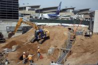 In this Monday, May 5, 2014 photo construction crews dig at Los Angeles International Airport, LAX. An ongoing, multibillion-dollar renovation at the nation's third-busiest airport that has mostly been behind the scenes will soon start affecting passengers in ways large and small. LAX officials began warning the public about the coming inconveniences that will stretch over the next few years and affect traffic around the terminals and passenger movements inside them. (AP Photo/Nick Ut )