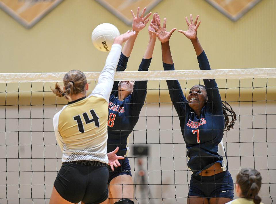 Treasure Coast High School's Jenna Simmons (left) spikes a shot past St. Lucie West Centennial's Isabel Narbutus (center) and Shayla Henry during their opening game at Treasure Coast High School gym on Thursday, Sept. 15, 2022, in Port St. Lucie. St. Lucie West Centennial won in 3 out of 5 games.