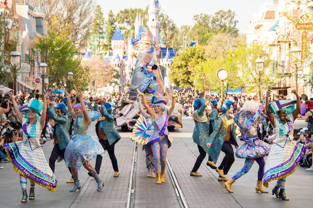 Sorcerer Mickey and color cast members help celebrate the magic of Disney in Disneyland's "Magic Happens" parade.
