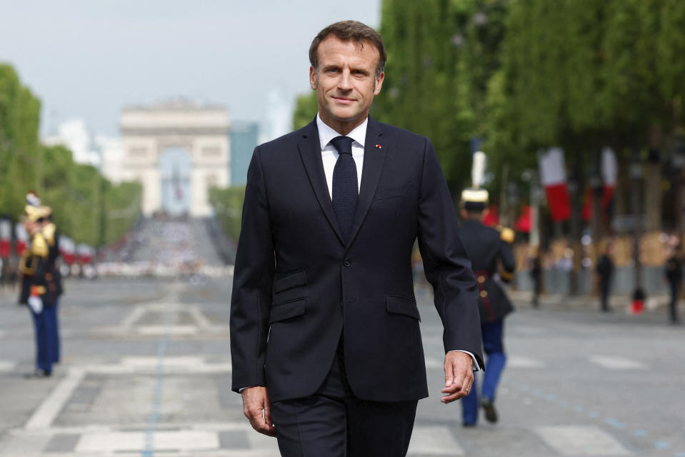 French President Emmanuel Macron walks on the Champs-Elysees avenue during the annual Bastille Day military parade, in Paris, Friday, July 14, 2023. India is the guest of honor at this year's Bastille Day parade, with Prime Minister Narendra Modi set to watch in the presidential tribune alongside French President Emmanuel Macron. (Gonzalo Fuentes/Pool via AP)