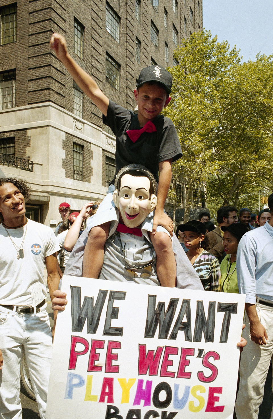 Anthony Hayden, 12, of Bensonhurst, Brooklyn sits on the shoulders of Shelly Buschel at a rally in support of Pee Wee Herman in New York's Greenwich Village, Aug. 8, 1991. Some 400 supporters denounced Paul Reuben's arrest for indecent exposure and praised his television show for bringing 