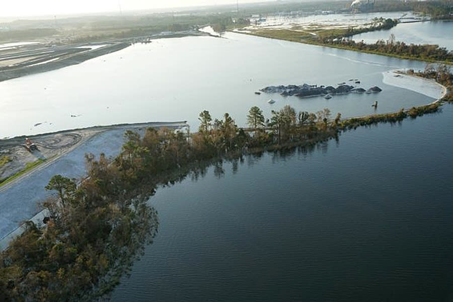 In this photo released by Duke Energy, The Sutton 1971 coal ash basin is seen Sept. 21, 2018, near Wilmington, N.C. Duke spokeswoman Paige Sheehan said Friday that floodwaters continue to overtop an earthen dike at the north side of Sutton Lake, a 1,100-acre (445-hectare) reservoir at the L.V. Sutton Power Station. (Duke Energy via AP)