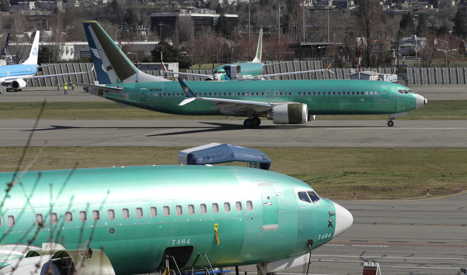 FILE- In this March 22, 2019, file photo a Boeing 737 Max 8 being built for Oman Air, top, taxis before takeoff from Renton Municipal Airport in Renton, Wash. Boeing is under investigation on multiple fronts. The Justice Department is looking into possible criminal violations involving certification that the 737 Max introduced in 2017 was safe. Congressional committees are also investigating the crashes and questioning a program under which the FAA delegates many safety checks for planes to Boeing and other manufacturers to save money. (AP Photo/Ted S. Warren, File)