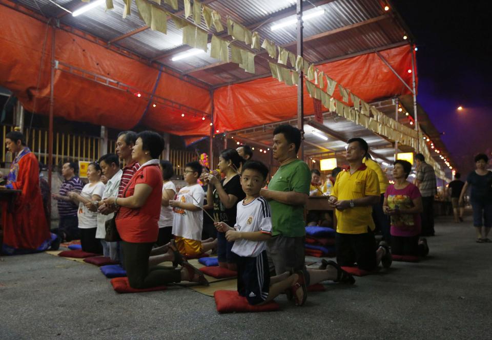 People pray during the Hungry Ghost festival in Kuala Lumpur