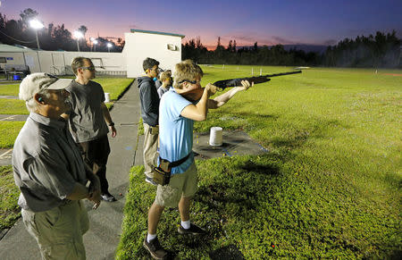 Garrett Hole (C), 16, shoots as instructor Joe Loitz (L) looks on at left during a clay target youth group shooting meeting in Sunrise, Florida, U.S., February 26, 2018. Picture taken February 26, 2018. REUTERS/Joe Skipper