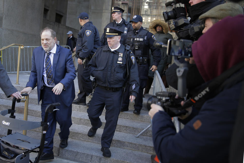 Harvey Weinstein, left, leaves a Manhattan courthouse after closing arguments in his rape trial in New York, Friday, Feb. 14, 2020. (AP Photo/Seth Wenig)