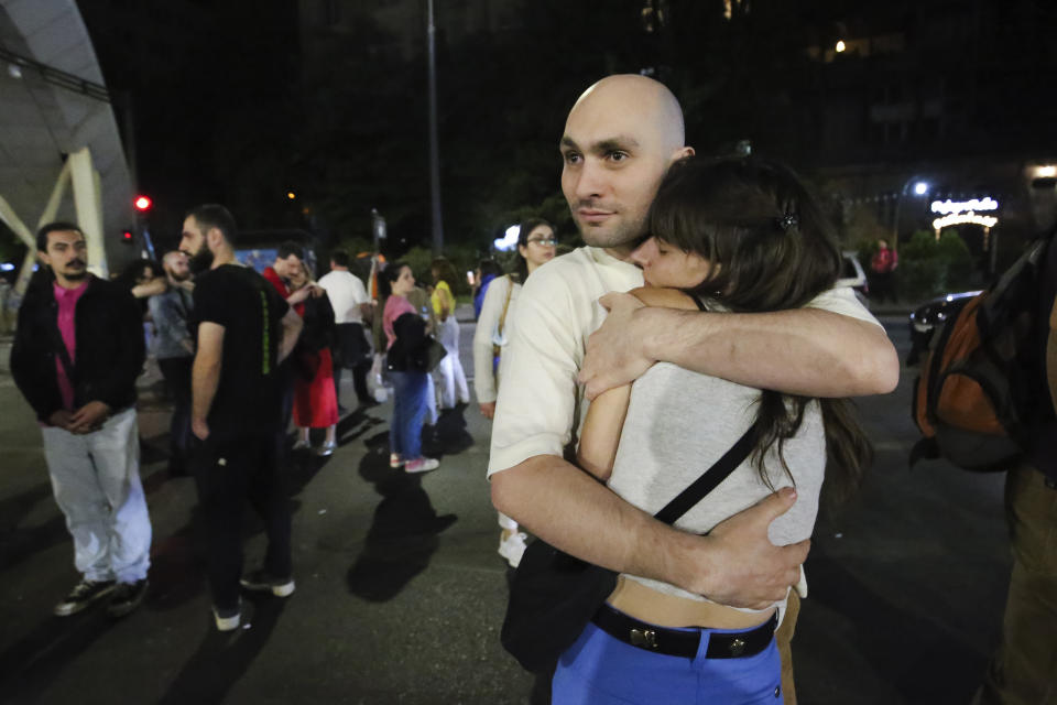 A couple embrace during an opposition protest against "the Russian law" near the Parliament building in Tbilisi, Georgia, on Wednesday, May 1, 2024. Clashes erupted between police and opposition demonstrators protesting a new bill intended to track foreign influence that the opposition denounced as Russia-inspired. (AP Photo/Zurab Tsertsvadze)