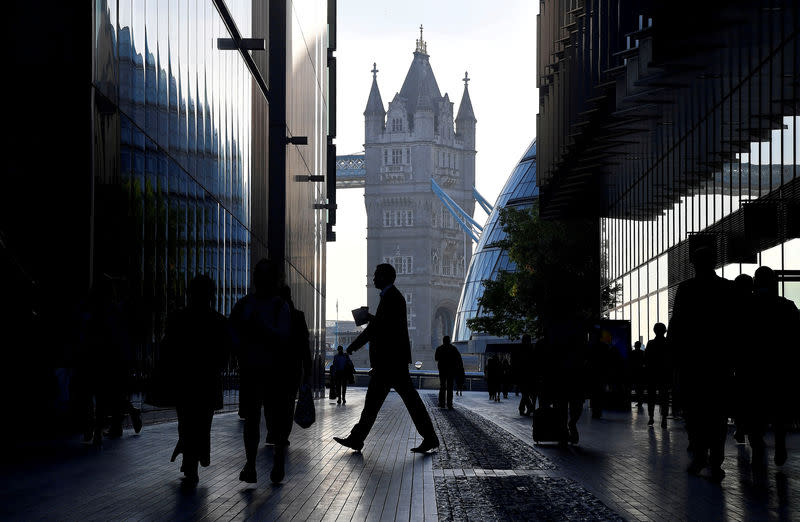 FILE PHOTO: Workers are seen in the More London district, with Tower Bridge behind during the morning rush hour in London, Britain, September 25, 2018. REUTERS/Toby Melville