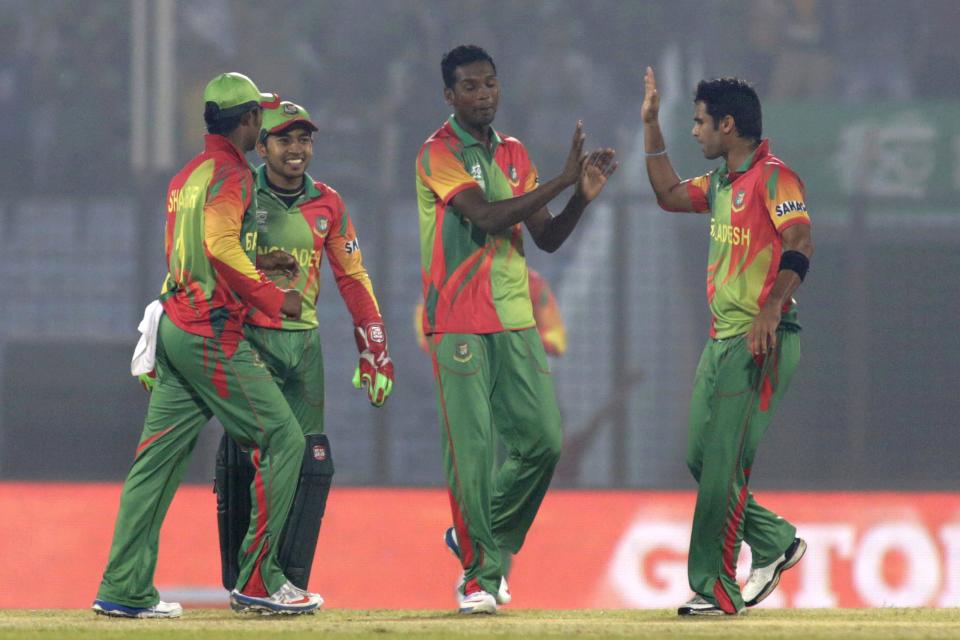 Bangladesh's Al-Amin Hossain, center, celebrates with teammates the fall of Nepalese wicket during their ICC Twenty20 Cricket World Cup match in Chittagong, Bangladesh, Tuesday, March 18, 2014. (AP Photo/Bikas Das)