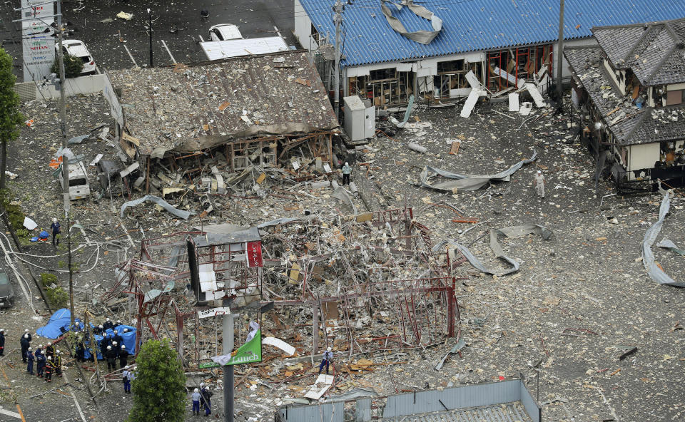 Investigators work near a damaged building following an explosion in Koriyama, Fukushima prefecture, northern Japan Thursday, July 30, 2020. At least more than a dozen people were injured and being taken to hospitals after a sudden explosion blew off walls, windows and debris in the neighborhood. (Kyodo News via AP)