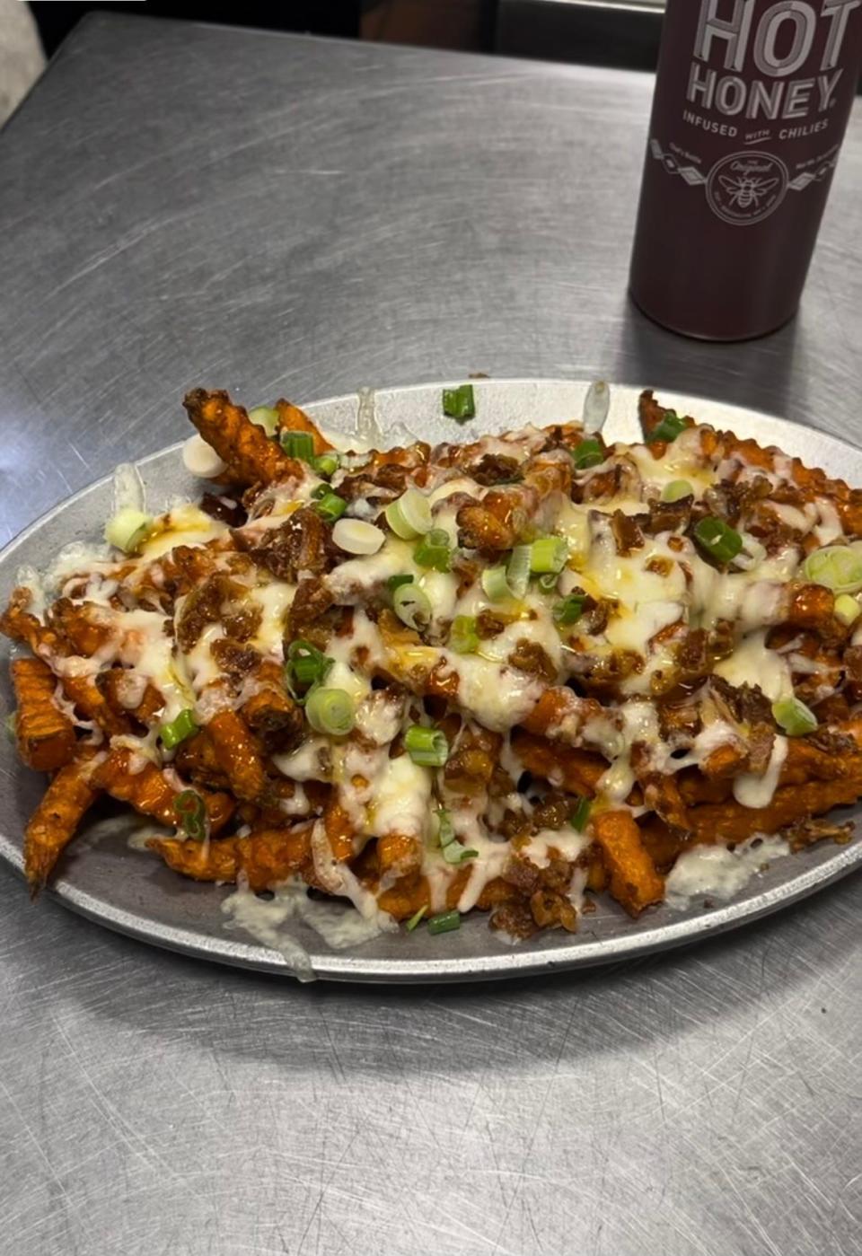 Loaded sweet potato fries come topped with Mike's Hot Honey sauce at Sidelines Bar & Grill in Fairfield, New Jersey.