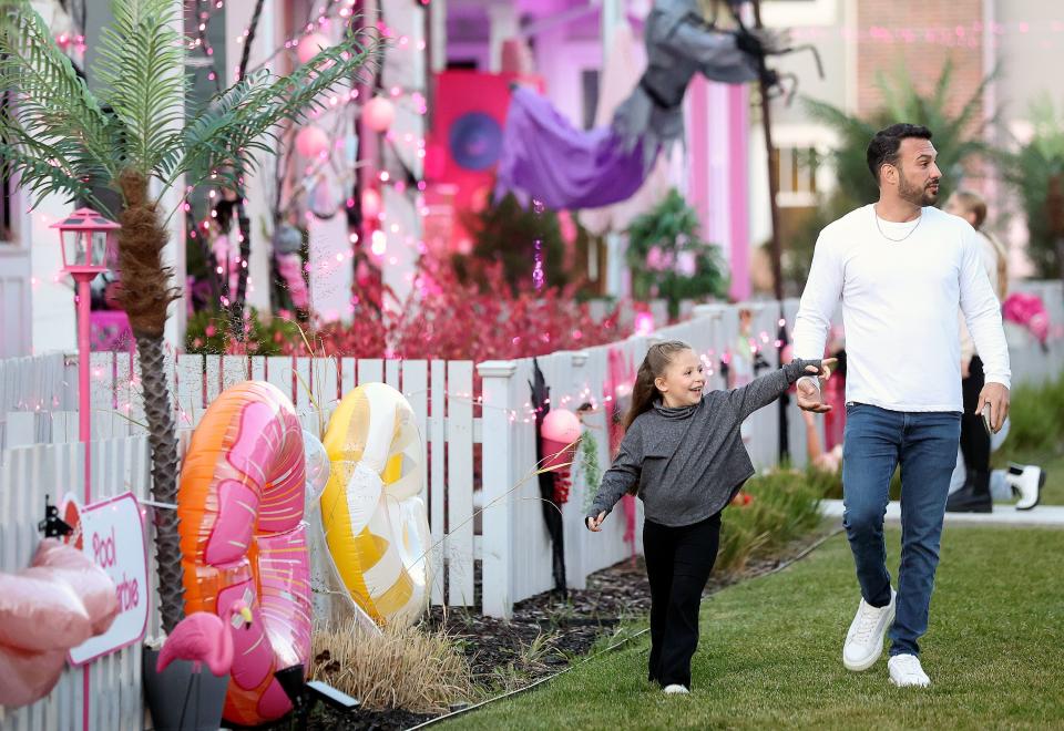 Macie Chaparro and her father Lost Chaparro walk through a Daybreak neighborhood that is decorated in a Barbie theme for Halloween in South Jordan on Friday, Oct. 13, 2023. | Kristin Murphy, Deseret News