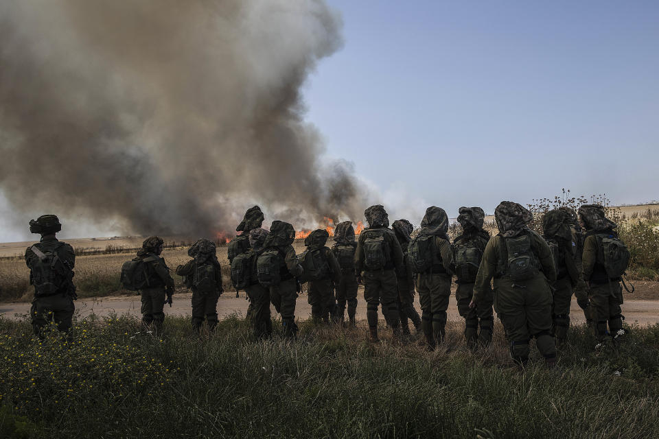 FILE - Israeli soldiers watch a wheat field burn next to Kibbutz Nahal Oz along the Israel-Gaza border, Monday, May 14, 2018. (AP Photo/Tsafrir Abayov)