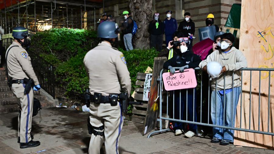 Police officers face protesters as they stand guard after clashes on the campus of the University of California Los Angeles (UCLA), in Los Angeles on May 1, 2024.
