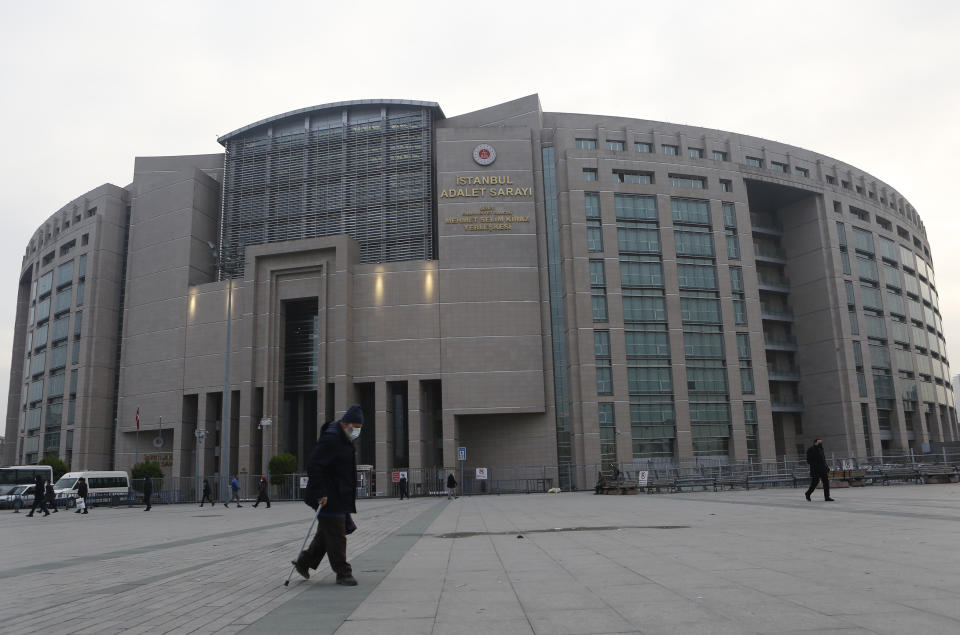 A man walks outside a court where the case against Can Dundar, the editor-in-chief of opposition newspaper Cumhuriyet on espionage and terror-related charges, was held, in Istanbul, Wednesday, Dec. 23, 2020. The court in Istanbul on Wednesday found Dundar guilty of “obtaining secret documents for espionage” and “aiding a terrorist organization,” sentencing him to a total of 27 1/2 years in prison. (AP Photo/Mehmet Guzel)