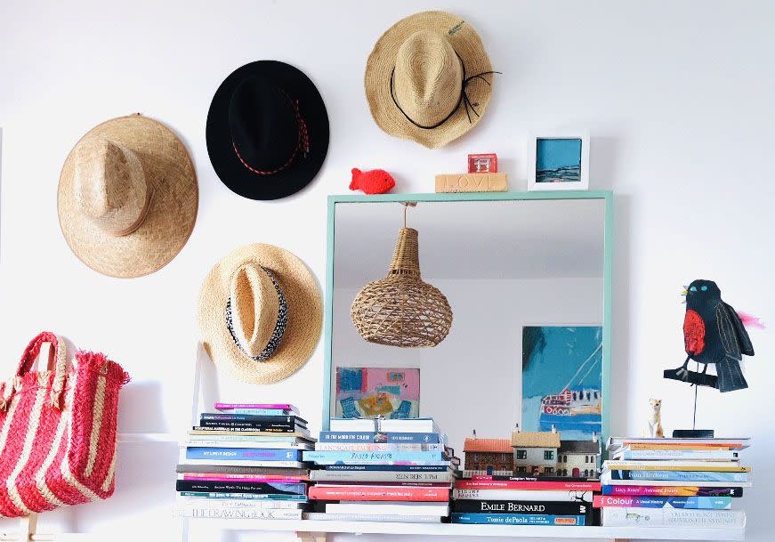 <p>"I keep stacks of books everywhere, mostly art books, to ensure I feel constantly inspired. We also have a collection of hats hung up, that all have special memories."</p>