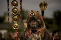 A participant in the Romula Fest historic reenactment event, wearing a Roman legion uniform and a bear fur stands in the village of Resca, Romania, Sunday, Sept. 4, 2022. Members of historic NGOs and volunteers gathered in a field outside a southern Romanian village, once part of the Romula Malva, Roman Empire era city, aiming to raise awareness for history through realistic reenactments of battles between Roman legions and local Dacian tribes.(AP Photo/Andreea Alexandru)