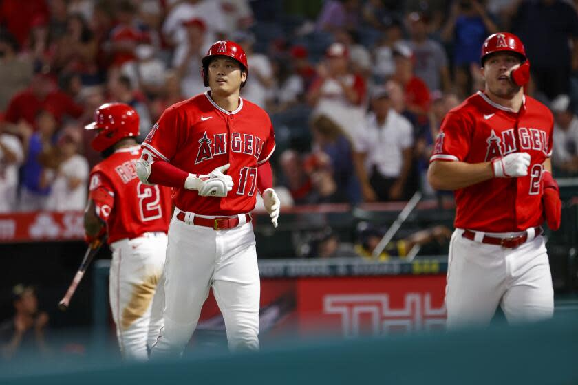 ARCHIVO - Foto del 5 de septiembre del 2022, Shohei Ohtani y Mike Trout de los Angelinos corren al dugout en el juego ante los Tigres de Detroit. (AP Foto/Ringo H.W. Chiu, Archivo)