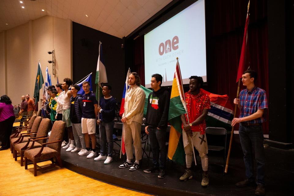 International students stand in front of the student body holding the flags of their home country during International Student Day in Loyd Auditorium at Freed-Hardeman University in Henderson, Tenn., on Thursday, February 23, 2023. Students representing 19 countries carried their home country flags into the auditorium and then introduced their countries. 