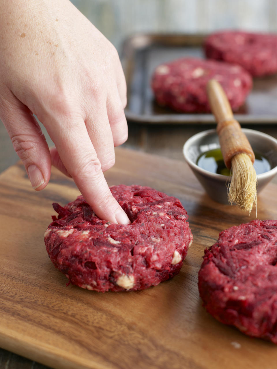 After shaping hamburger patties, make an indention in the center with your finger. Since the sides cook down faster then the center of the patty this trick will actually make the burger flat instead of rounded <a href="http://www.huffingtonpost.com/2014/07/17/flat-hamburger-patty_n_5531011.html" target="_blank">making it <em>way</em> better</a>. And flat burgers mean the toppings will stay where they belong -- on top.