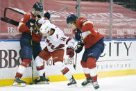 Florida Panthers center Eetu Luostarinen (27) and right wing Owen Tippett, right, battle for the puck with Carolina Hurricanes defenseman Jake Bean (24) during the second period of an NHL hockey game, Monday, March 1, 2021, in Sunrise, Fla. (AP Photo/Wilfredo Lee)