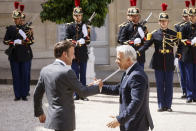 French President Emmanuel Macron, left, welcomes Israel's Prime Minister Yair Lapid Tuesday, July 5, 2022 at the Elysee Palace in Paris. It was the first overseas trip by Yair Lapid since he took office last week. (AP Photo/Thomas Padilla)