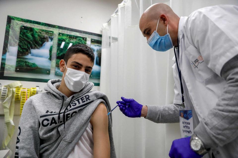 JERUSALEN ESTE: Un trabajador de la salud administra una dosis de la vacuna Pfizer-BioNtech COVID-19 a un hombre en los Servicios de Salud de Clalit en el barrio palestino de Beit Hanina, en el este de Jerusalén, anexado por Israel, el 2 de marzo de 2021.