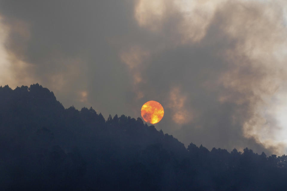 The sun rises during a forest fire on El Cable Hill in Bogota, Colombia, Thursday, Jan. 25, 2024. (AP Photo/Fernando Vergara)