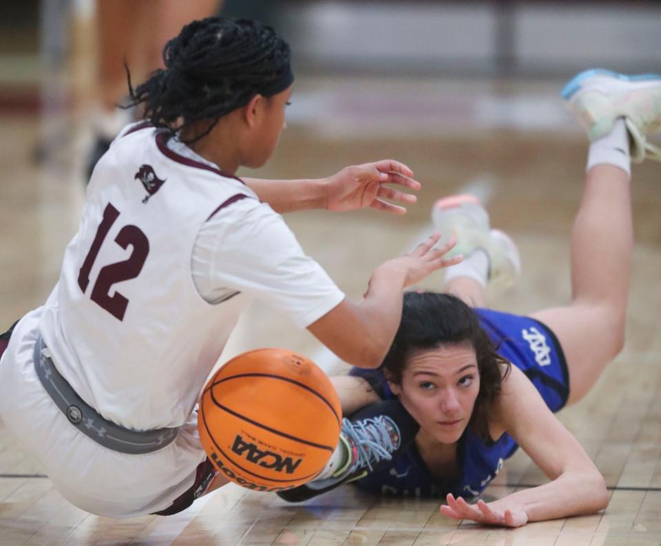Caravel's Jasiyah Crawford (12) and Charter School of Wilmington's Danielle Kanse battle for a loose ball in the Buccaneers' 57-42 home win, Friday, Feb. 17, 2023.