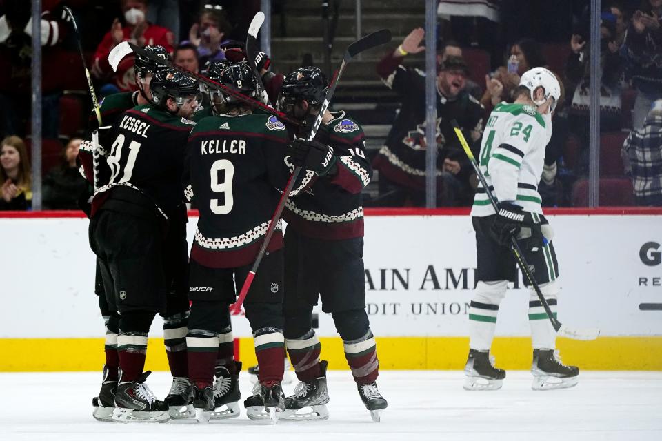 Arizona Coyotes center Nick Schmaltz (8) celebrates his goal against the Dallas Stars with Coyotes left wing Lawson Crouse, back left, Coyotes right wing Phil Kessel (81), Coyotes right wing Clayton Keller (9) and Coyotes defenseman Shayne Gostisbehere, second from right, as Stars center Roope Hintz (24) skates away during the second period of an NHL hockey game Sunday, Feb. 20, 2022, in Glendale, Ariz. (AP Photo/Ross D. Franklin)