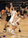 Providence's Alyn Breed, left, slips past Villanova's Justin Moore, right, and Collin Gillespie, center, during the second half of an NCAA college basketball game Saturday, Jan. 23, 2021, in Villanova, Pa. Villanova won 71-56. (AP Photo/Chris Szagola)