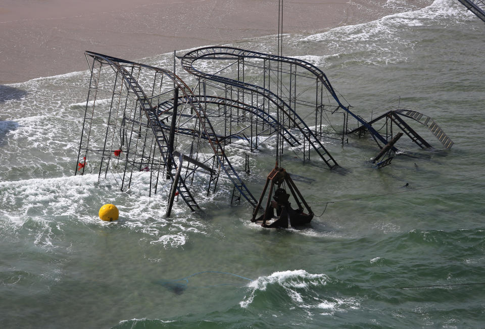 SEASIDE HEIGHTS, NJ - MAY 14:  A crane demolishes the JetStar roller coaster more than 6 months after it fell into the ocean during Superstorm Sandy on May 14, 2013 in Seaside Heights, New Jersey. The Casino Pier contracted Weeks Marine to remove the wreckage of the iconic roller coaster from the surf.  (Photo by John Moore/Getty Images)