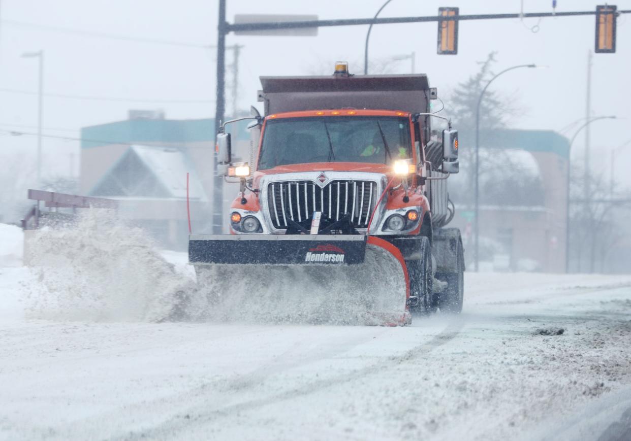 A city of Akron snowplow clears East Market Street near South Arlington Street in Akron on Friday.