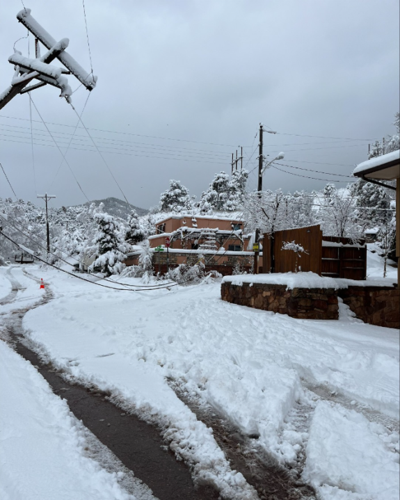 A damage power line rests across a street in Colorado Springs