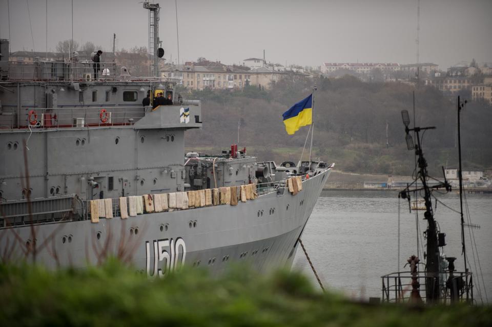 A Ukrainian national flag flies on the board of Ukrainian navy ship Slavutich, at harbor of in Sevastopol, Ukraine, Tuesday, March 4, 2014. Crimea still remained a potential flashpoint. Pro-Russian troops who had taken control of the Belbek air base in Crimea fired warning shots into the air Tuesday as around 300 Ukrainian soldiers, who previously manned the airfield, demanded their jobs back.(AP Photo/Andrew Lubimov)